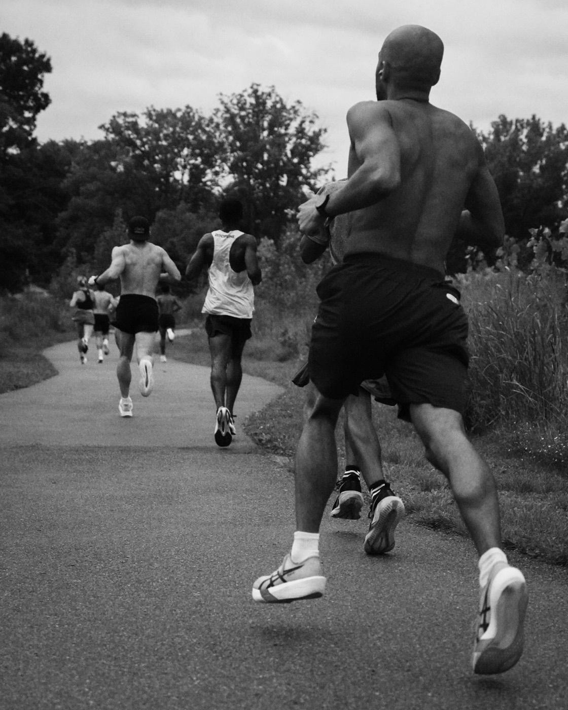 Runners chasing each other down a path at the After Hours 3K