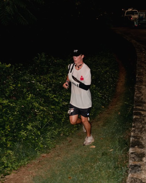 A runner on a grass trail at night during the Outlast RVA Backyard Ultra