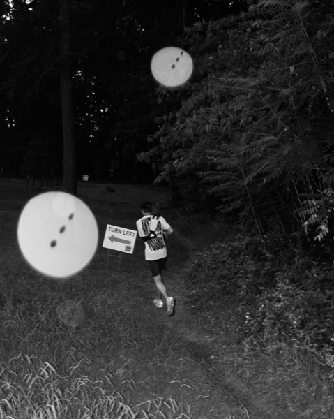 A runner passing a turn-left sign on a trail at the Outlast RVA Backyard Ultra