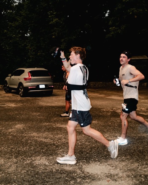 A runner cheering mid-stride at the Outlast RVA Backyard Ultra