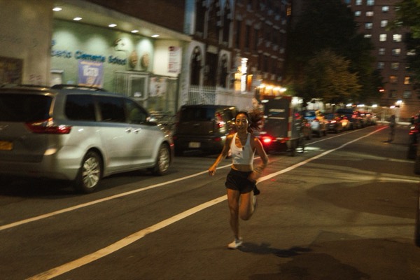 A runner racing down a city street at night during Supermarket Race 1