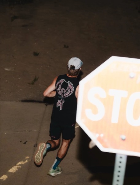 A runner passing a stop sign at night during the Vivo Midnight 25K/50K